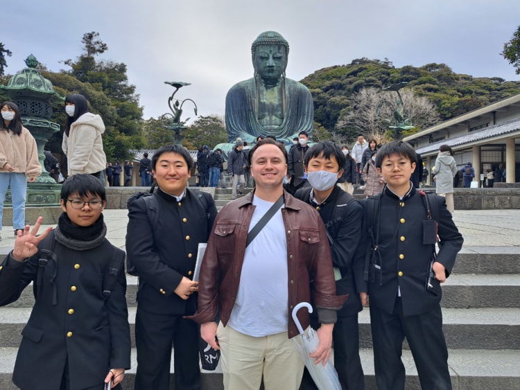 鎌倉大仏の前に集まる鎌倉学園中学校・高等学校ESSに所属する生徒と外国人観光客