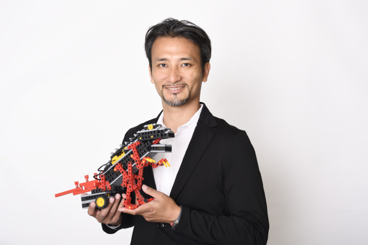 ロボットクリエイターの高橋智隆先生と恐竜型のロボット「ロボザウルス」