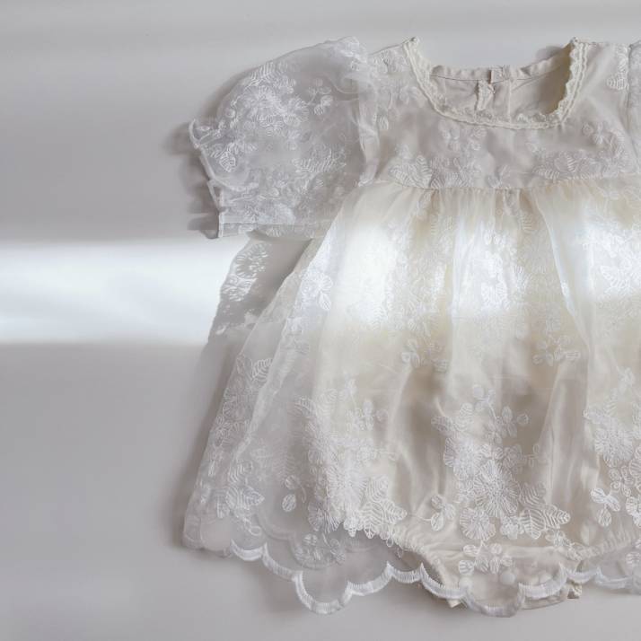 白いベビードレスに光が咲きこむ様子をとらえた写真