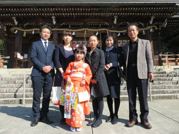 物部神社の拝殿前で七五三の記念撮影をする家族