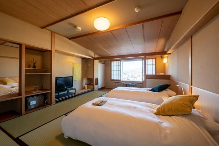 onsen hotel OMOTOにあるシモンズベッドを備えた和室