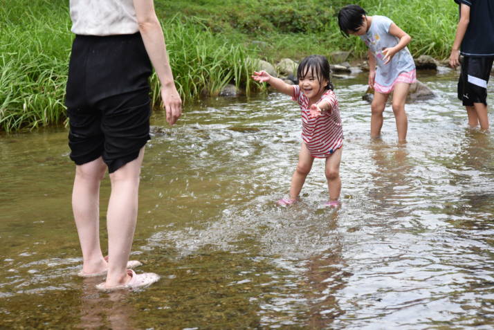 京都大呂ガーデンテラスの小川で遊んでいる家族