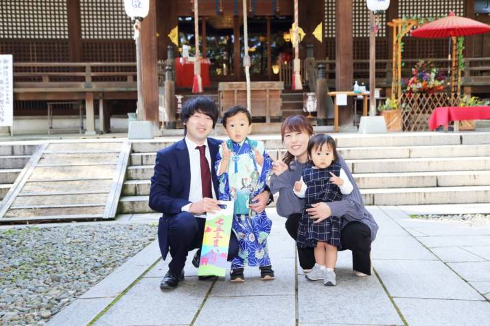 石川県小松市にある莵橋神社のお社の前で記念撮影をする家族