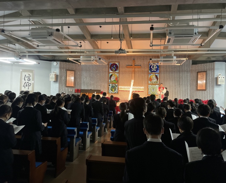 聖望学園中学校の礼拝堂に集まって讃美歌を歌う生徒たち