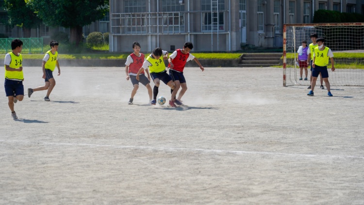 「滝中学・滝⾼等学校」の球技大会でサッカーをしている生徒