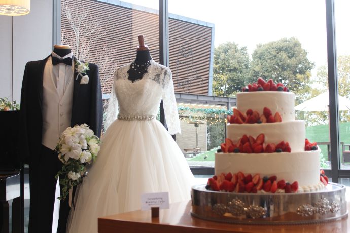 宇婚のミカタの婚活パーティー会場に飾られたウェディング衣装とウェディングケーキ